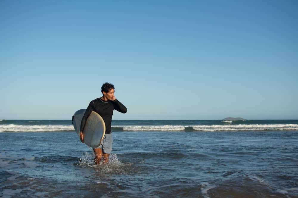 A surfer coming out of the ocean after being stung by sea lice in Florida