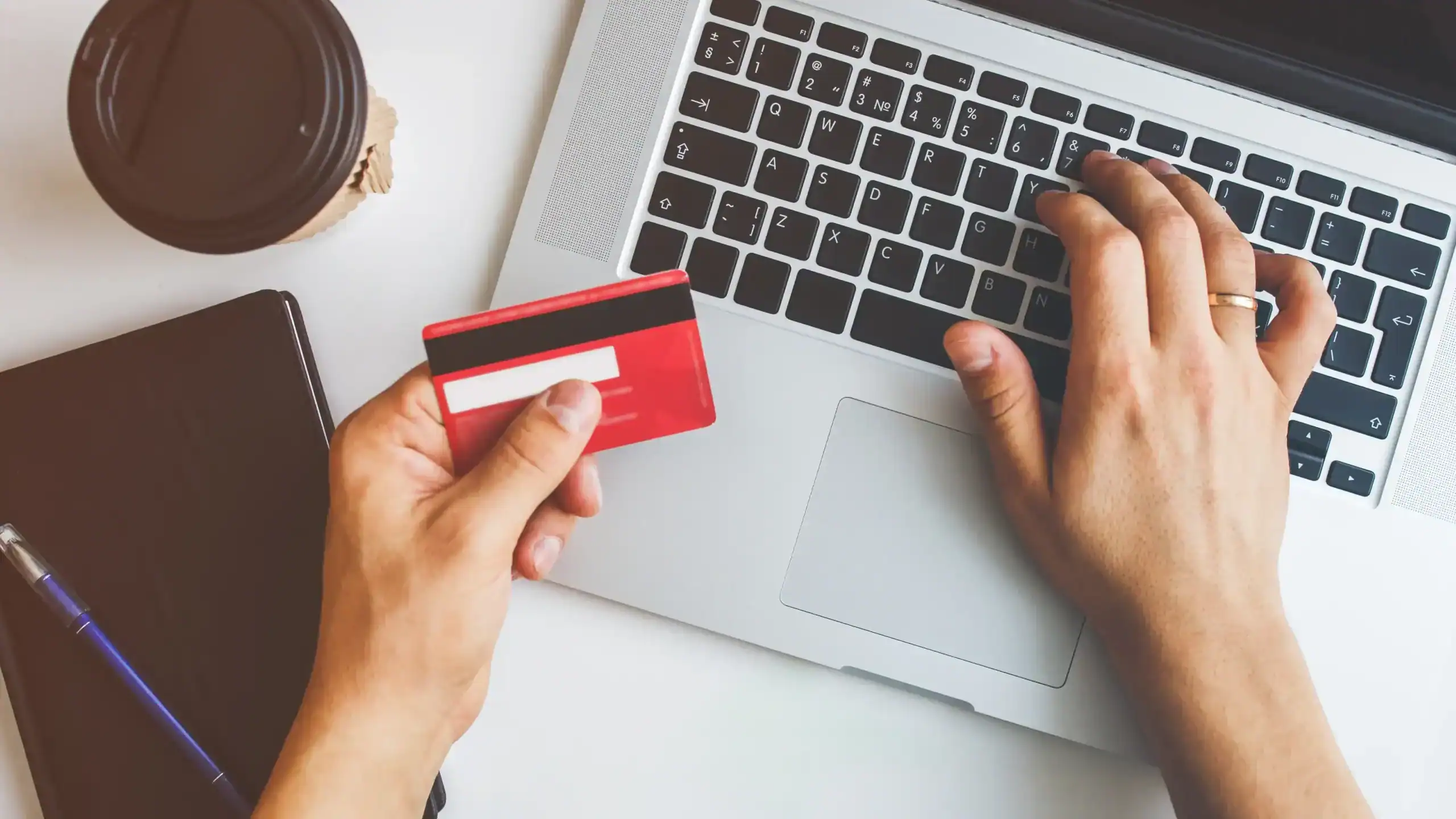man paying a bill online with a credit card and his computer