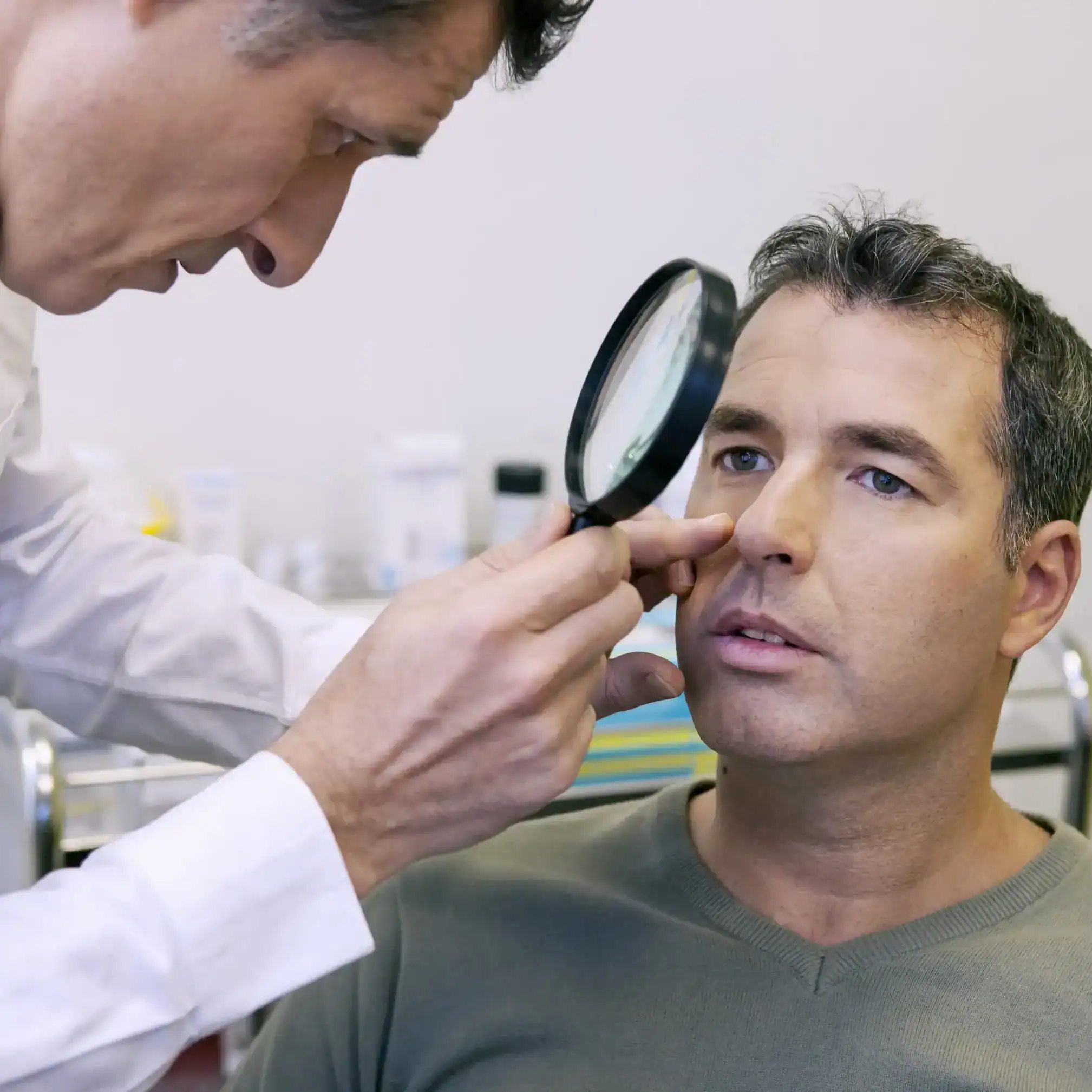 Middle aged adult male getting spot checked on his face