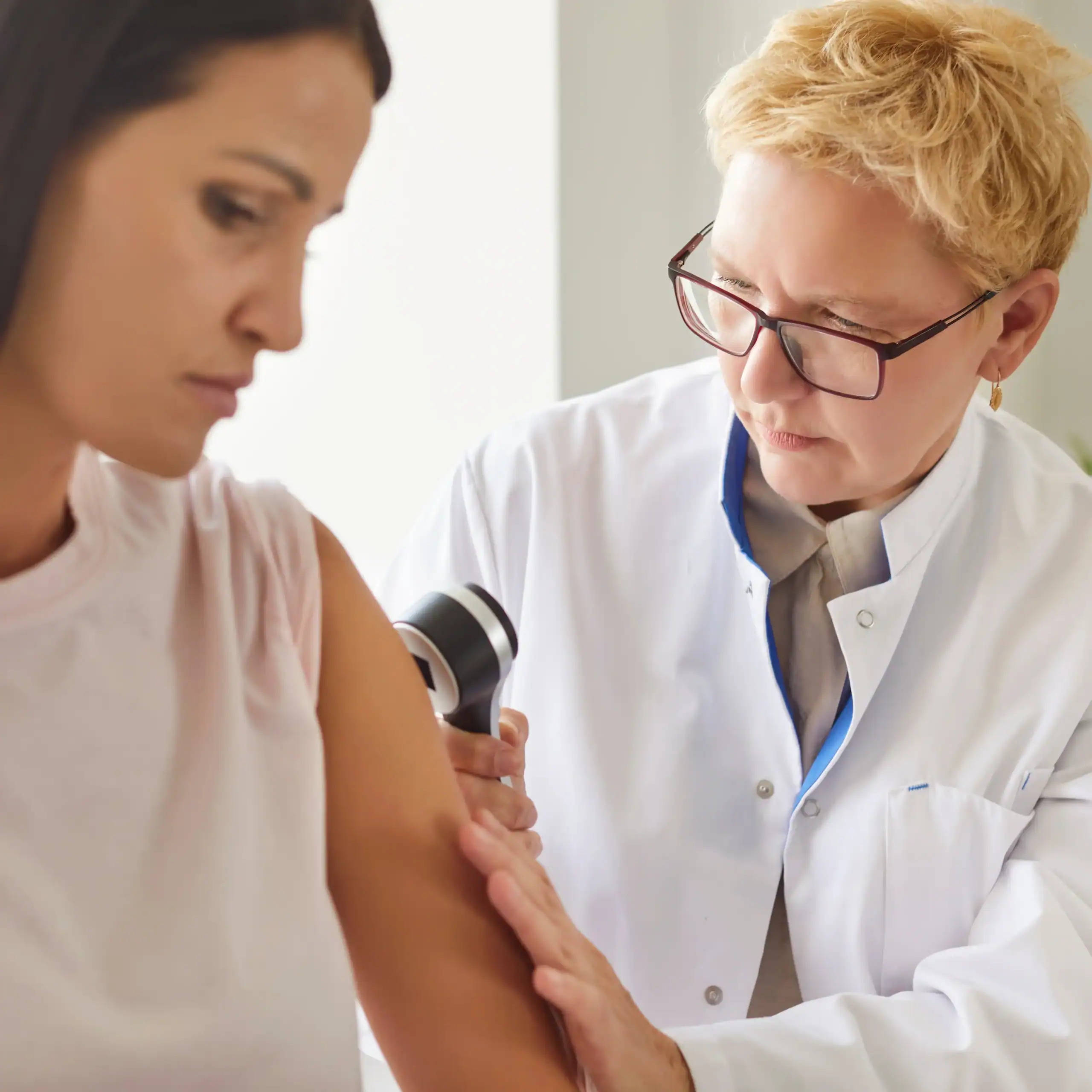 older dermatologist examines a patient