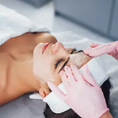 Younger woman getting a facial cosmetic treatment